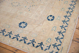 Khotan carpet border with dark blue geometric motifs and ivory field with worn texture.