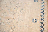 Vintage Khotan carpet, worn ivory field with scattered blue motifs and bold border.