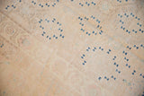 Worn texture and ivory field with dark blue geometric motifs on a vintage Khotan rug.