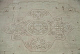 Oushak rug center medallion in soft ivory, platinum, and beige geometric and floral patterns.