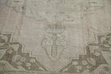 Soft beige and ivory curvilinear motifs with light brown border on the Oushak rug.