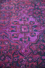 Textured pile showing saturated violet and deep purple geometric patterns.