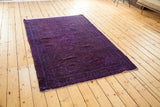 Vintage Hamadan overdye rug corner, showing rich violet pattern and light fringed edge.