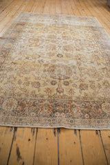 Distressed texture and faded floral motifs on the saffron yellow gold Turkish Sparta carpet.