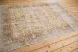 Distressed saffron gold Turkish Sparta carpet corner, worn texture with faded allover floral design.