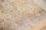 Distressed texture and faded floral design on the saffron yellow gold Sparta carpet border.