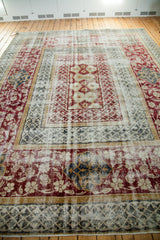 Decorative distressed texture showcasing rich burgundy floral and geometric motifs on this Oushak border.