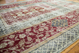 Distressed Oushak carpet border detail with whimsical stylized floral in blue and burgundy.