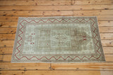 Distressed Oushak rug showcasing faded geometric motifs in platinum, light sage, and red.