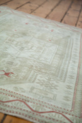 Soft distressed texture and muted platinum Oushak motifs with a subtle red border.