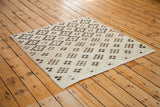 Distressed square and diamond motif Oushak rug in ivory, beige, and chocolate tones.