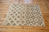 Distressed Oushak square rug in ivory, beige, chocolate bronze, and black geometric patterns.