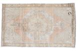 Vintage distressed Oushak rug featuring a grapefruit melon center medallion with muted neutral tones, 4'6