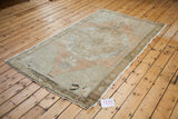 Distressed vintage Oushak rug corner, showing grapefruit melon, bronze hues, and worn texture.