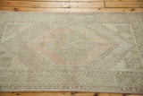 Distressed Oushak rug showing soft peach, beige, and ivory geometric medallion and patterns.