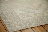 Distressed Oushak rug corner showing its soft beige tones and muted geometric design.