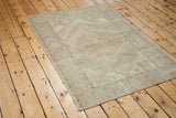 Light, airy distressed Oushak rug with soft peach, beige, and ivory shades.