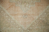 Soft, distressed Oushak rug texture with blended peach, lemon, and ivory tones.