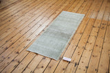 Faded sea foam green checker pattern on a distressed vintage Oushak runner.