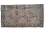 Distressed vintage Turkish Oushak rug with double medallion, peach field, and charcoal geometric border.