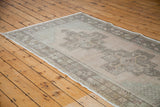 Distressed peach field with charcoal brown medallion motif on a vintage Oushak rug.