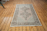 Distressed charcoal brown border with geometric floral motif and white fringe.
