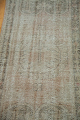 Distressed vintage Turkish Oushak rug showing worn pile texture in pale peach, ivory, and charcoal.
