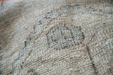 Distressed Oushak rug pile showing muted beige, soft slate blue, and charcoal tones.