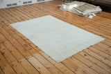 Distressed Oushak rug texture with soft ivory, lemon silver, and blue-grey hues.