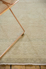 Distressed Oushak carpet showing textural pile in soft beige gold and faint rose.