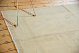Distressed Oushak carpet, highlighting its faded ivory color and airy texture.
