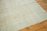 Distressed Oushak carpet texture in soft beige gold with light rose undertones.