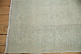 Distressed texture of a vintage Turkish carpet in faded pale silver and sage.