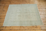 Vintage distressed Oushak carpet corner with faded pale silver pile and light fringe.