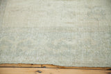 Distressed Oushak rug pile with even wear, featuring pale silver and sage tones.