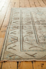 Faded geometric border and soft earth tones on this distressed Turkish Oushak rug.