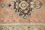 Faded orangey rose, ivory, charcoal geometric motifs on a vintage Oushak rug.