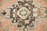 Close-up of Vintage Oushak rug's geometric medallion in faded orangey rose, ivory, and charcoal tones.