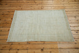 Worn texture of a distressed vintage Oushak rug in faded lemon ivory.