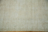 Worn lemon ivory Oushak rug texture, highlighting its subtly faded pattern.
