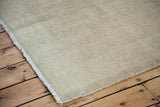 Distressed Oushak rug's worn fringed edge and subtle rose ivory white pile.