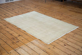 Distressed Oushak rug with soft rose ivory white shade and worn texture.