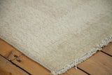 Reverse of a vintage Oushak rug, showcasing its hand-knotted foundation and natural ivory fringe.