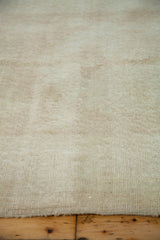 Distressed vintage Oushak rug's worn ivory and golden pile texture.