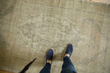 Distressed Oushak rug with pale earth tone colors and aged pattern.