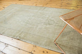 Distressed vintage Oushak rug showcasing faded texture in pale earth tone shades.
