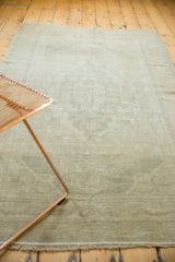 Distressed pale earth tone Oushak rug edge with short, worn fringe.