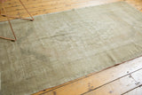 Pale earth tone distressed Oushak rug, showcasing faded patterns and soft texture.