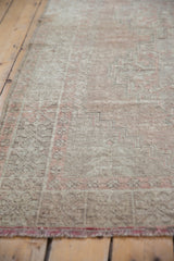 Distressed Oushak rug with faded brick rose geometric patterns and worn texture.