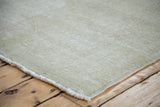 Blanched ivory and grey distressed Oushak rug with textured pile and short fringe.